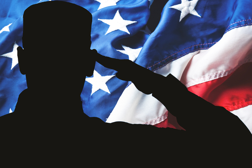 A service member salutes the American flag